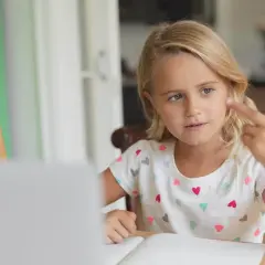 Meisje telt met vingers, leert rekenen met telraam. Hulpmiddelen voor dyslexie en dyscalculie.