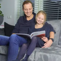 Vader en dochter lezen samen een rekenboek. De tafels flitsen door hun hoofd terwijl ze oefenen.