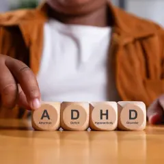 Een peuter met adhd legt blokjes met de letters A, D, H, D.