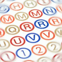 Letters en cijfers in cirkels, zoals 'R' en '2'. Dit doet denken aan de oorsprong van wat zijn leenwoorden, vaak overgenomen uit andere talen.