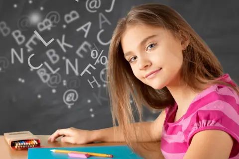 Een meisje leert wat studievaardigheden zijn, omringd door letters en symbolen op een schoolbord.