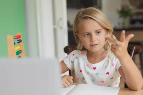 Meisje telt met vingers, leert rekenen met telraam. Hulpmiddelen voor dyslexie en dyscalculie.