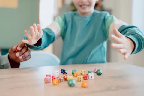 Kinderen spelen met dobbelstenen, een leuke manier om sommen voor groep 5 te oefenen.