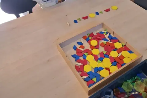 Kleurrijke geometrische vormen liggen klaar voor de grote rekendag. Kinderen kunnen hiermee patronen leggen en de wereld van wiskunde ontdekken.