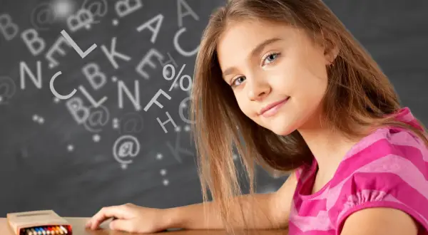 Een meisje leert wat studievaardigheden zijn, omringd door letters en symbolen op een schoolbord.