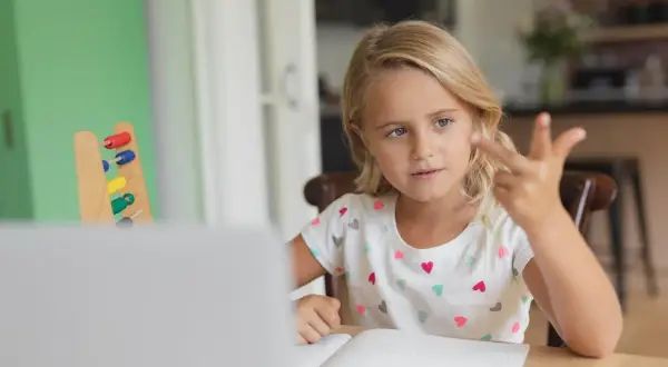 Meisje telt met vingers, leert rekenen met telraam. Hulpmiddelen voor dyslexie en dyscalculie.