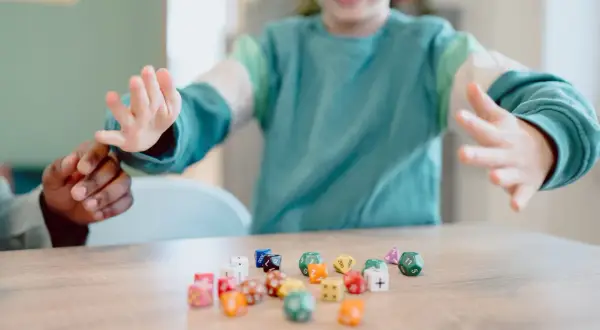 Kinderen spelen met dobbelstenen, een leuke manier om sommen voor groep 5 te oefenen.