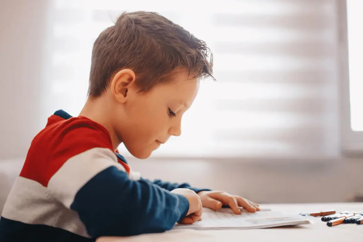 Jongen met dyslexie oefent begrijpend lezen, geconcentreerd op zijn werk.