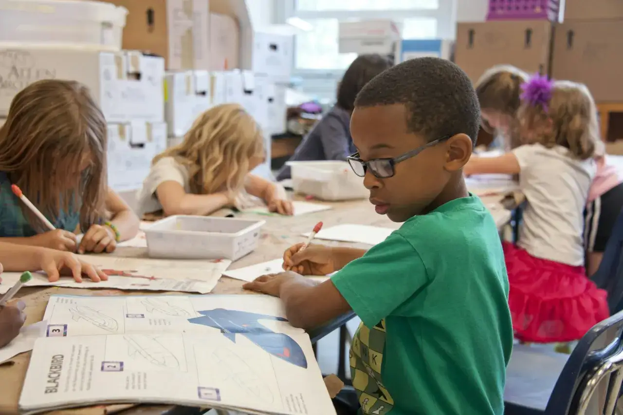 Kinderen werken geconcentreerd aan hun opdrachten, waarbij ze zichtbaar leren van elkaar.
