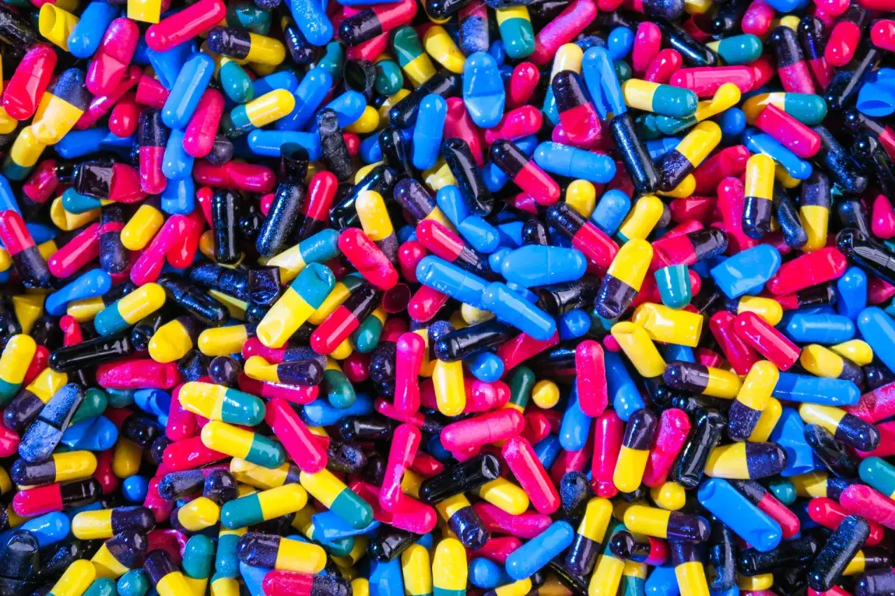 Een kleurrijke stapel pillen, die medicatie bij overprikkeling autisme symboliseert.