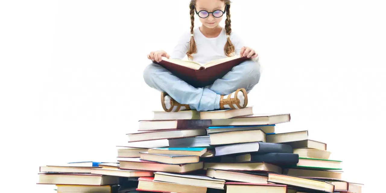 Een meisje met vlechten en een bril zit op een stapel boeken en leest. Ze is omringd door vele fantasia boeken, wat haar leeftijd van lezen weerspiegelt.