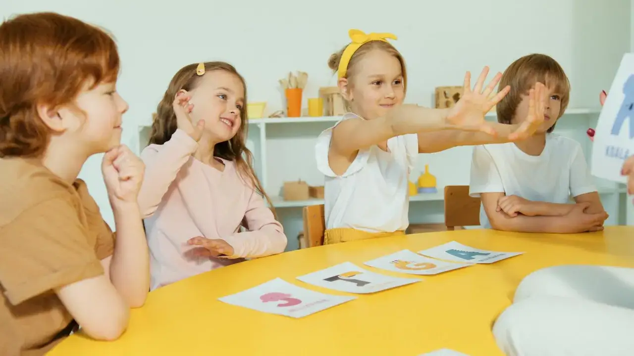 Kinderen leren met plezier over dieren. Een meisje met een gele strik toont haar hoog intelligente reactie op de les.