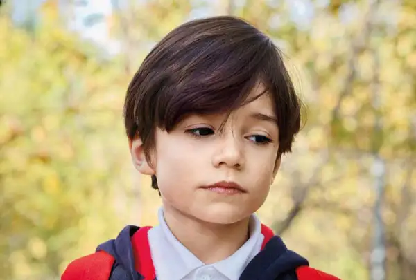 Een jongen met autisme kijkt peinzend weg, de schooluitval dreigt.