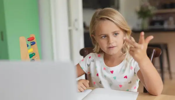 Meisje telt met vingers, leert rekenen met telraam. Hulpmiddelen voor dyslexie en dyscalculie.